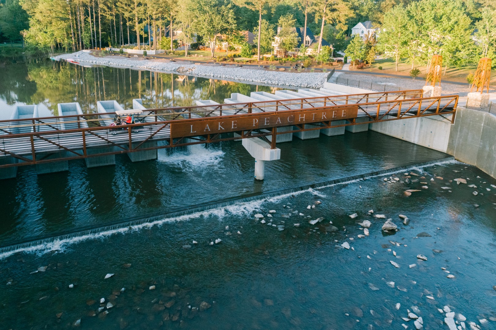 Lake Peachtree pedestrian bridge with fountains and scenic waterfront